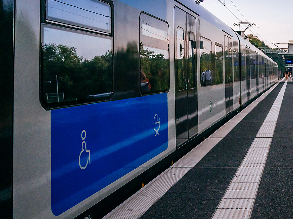 Man sieht den Bahnsteig mit dem Blindenstreifen. Daneben steht eine S-Bahn