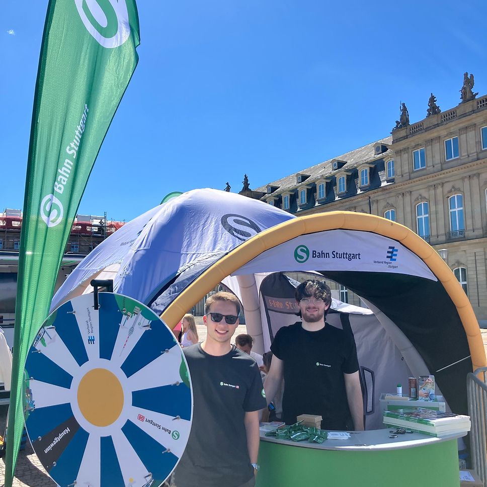 Unsere Mitarbeiter von der S-Bahn Stuttgart stehen neben dem Glücksrad auf dem Kinder- und Familienfestival.