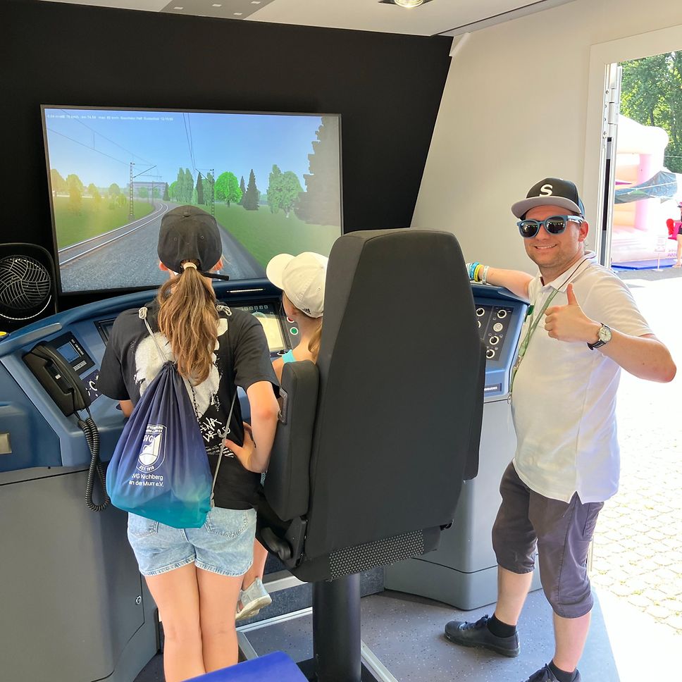 Trainer zeigt den daumen nach oben am Simulator