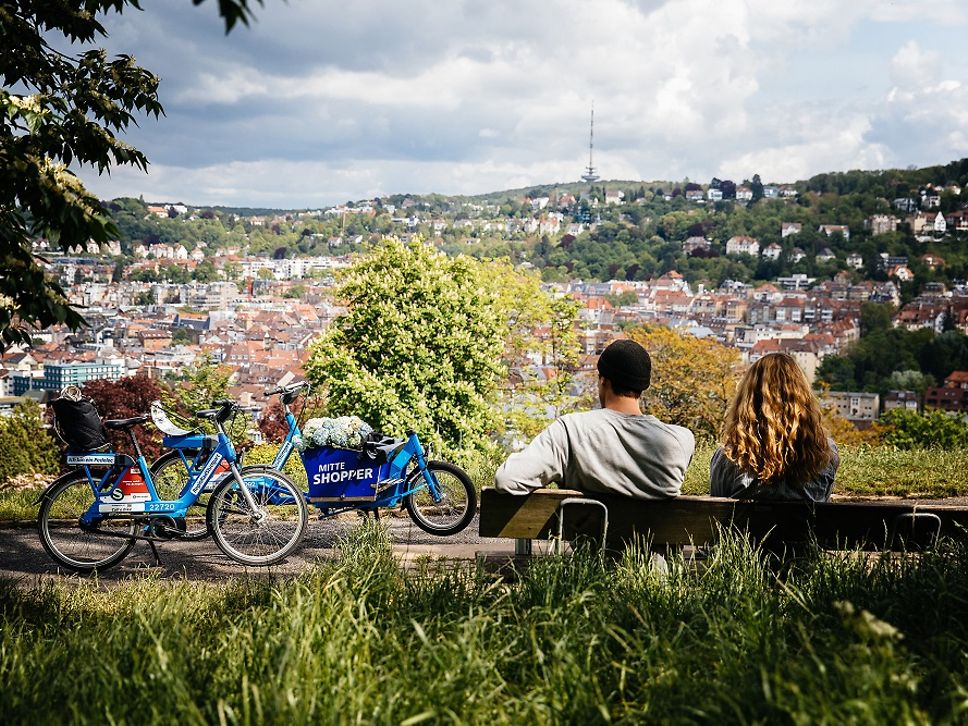ein Pärchen sitzt auf einer Bank mit dem Blick über Stuttgart. Im Hintergrund ist das RegioRad zu erkennen.